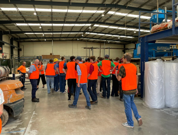 A group of people wearing orange vest at the warehouse