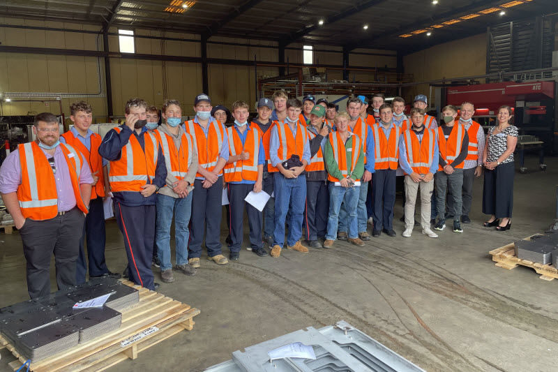 Group of employees wearing orange safety vest looking at the camera